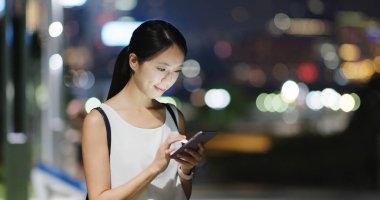 Gece akıllı telefon kullanan bir kadın.