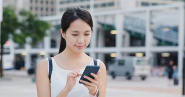 Şehirde akıllı telefon kullanan bir kadın