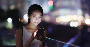 cep telefonuyla şehirde gece kadın