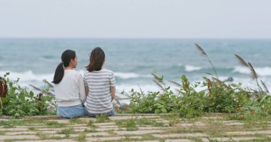 Sohbet ve deniz kenarında oturan genç kadın