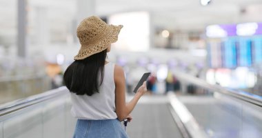 Havaalanında cep telefonu kullanan kadın