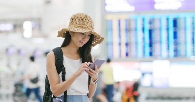 Uçuş numarasını havaalanında cep telefonu üzerinde kontrol kadın