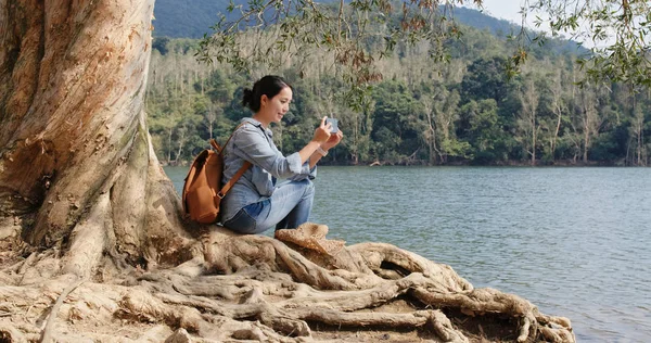 Donna Scattare Foto Sul Cellulare Sedersi Sulla Radice Del Vecchio — Foto Stock