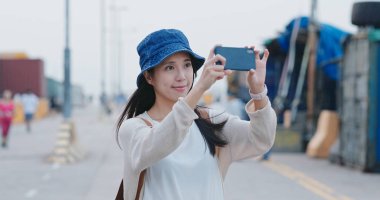 Turist kadın Hong Kong işareti cep telefonu fotoğraf almak