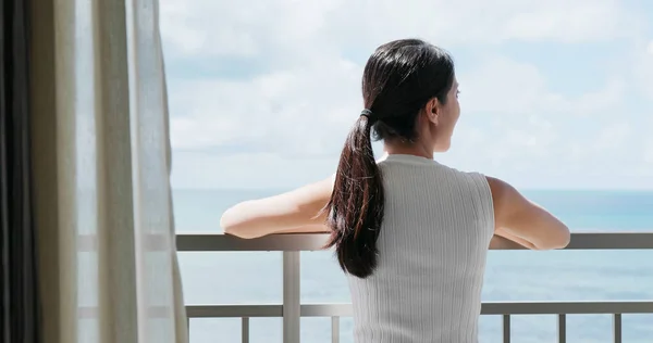 Woman looking  at the sea view at balcony