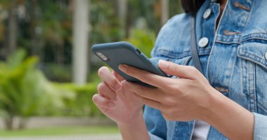 Parkta cep telefonu kullanan kadın