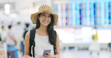 Kadın holding cep telefonu ve gülümseme fotoğraf makinesi için