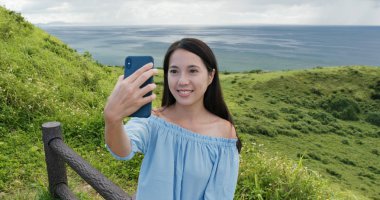 Kadın Ishigaki Adası landmark cep telefonu selfie almak