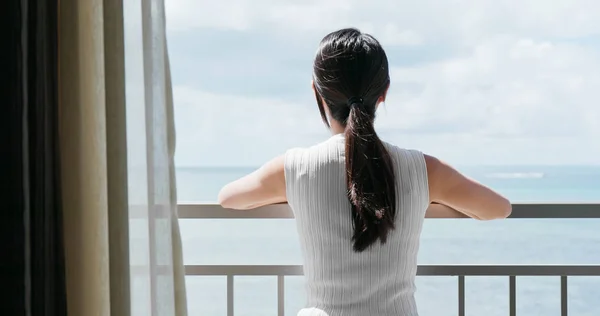 Woman looking  at the sea view in the balcony