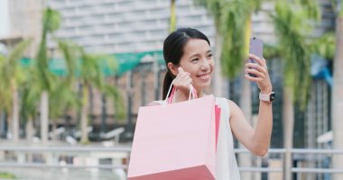 Alışveriş torbaları holding ve selfie cep telefonu alarak kadın