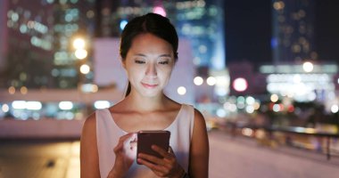 Genç kadın cellphone şehir içinde a geceleri sms gönderme