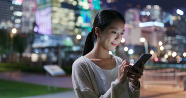 Şehirde akıllı telefon kullanan bir kadın