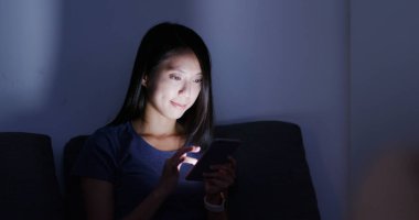 Cep telefonu evde akşamları kullanan kadın