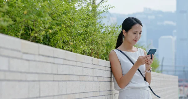 女性は街の携帯電話を見て — ストック写真