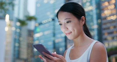 Cep telefonu şehirde geceleri kullanan kadın