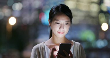 Şehirde akıllı telefon kullanan bir kadın