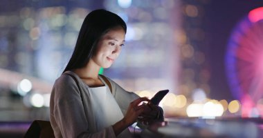 cep telefonuyla şehirde gece kadın