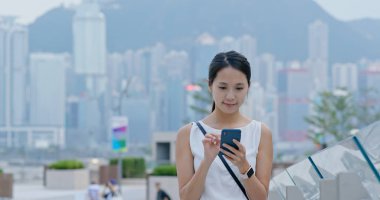 Kadın beklemek İstasyonu ve şehir içinde istimal hareket eden telefon