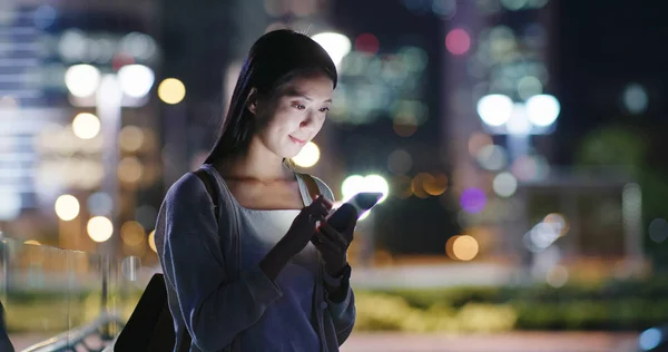 Woman using mobile phone at night