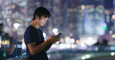 Adam cep telefonuyla şehirde geceleri