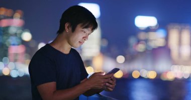 Gece şehirde cep telefonu kullanan adam