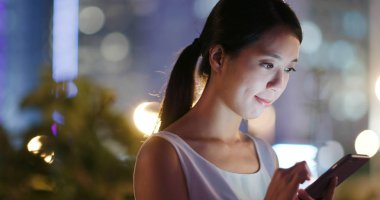 Cep telefonu online şehirde geceleri kullanan kadın