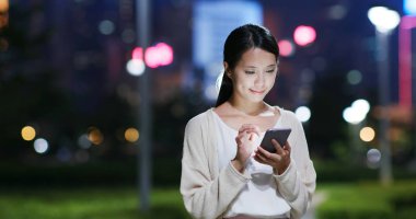 parkta cep telefonu kullanan kadın