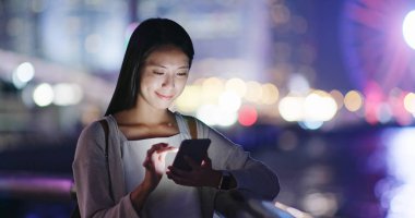 cep telefonuyla şehirde gece kadın