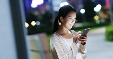 parkta cep telefonu kullanan kadın