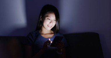 Akşamları evde cep telefonu kullanan kadın