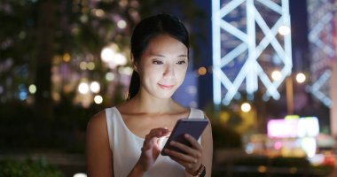 cep telefonuyla şehirde gece kadın