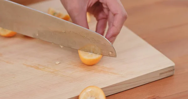 Person Schneidet Kumquat Mit Messer — Stockfoto