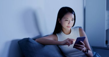 Cep telefonu evde akşamları kullanan kadın