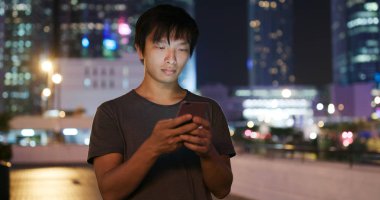 Adam cep telefonuyla şehirde geceleri