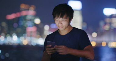 Adam cep telefonuyla şehirde geceleri