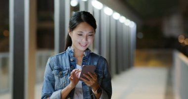 Geceleri smartphone şehirde kadın okuyun