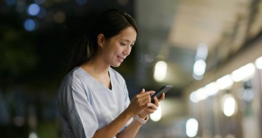 Geceleri cep telefonu kullanan kadın