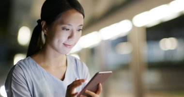 Kadın geceleri cep telefonuyla çalışıyor.