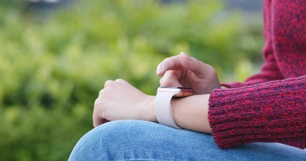 Woman using smart watch in the park