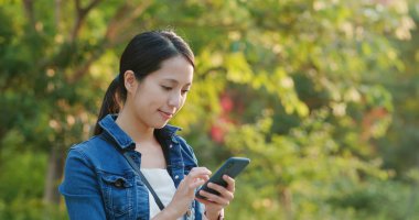 Şehir Parkı içinde cep telefonu kullanan kadın