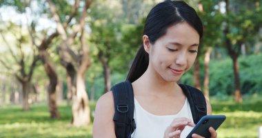 Parkta cep telefonu kullanan kadın