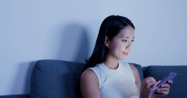 Evde cep telefonu kullanan bir kadın