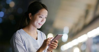 Kadın geceleri cep telefonuyla çalışıyor.