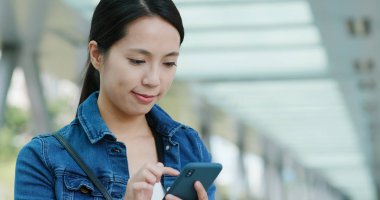 Kadın iş üstünde hareket eden telefon, iş bölgesinde