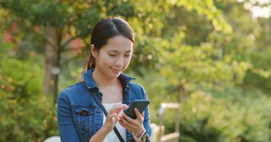 Şehir Parkı içinde cep telefonu kullanan kadın