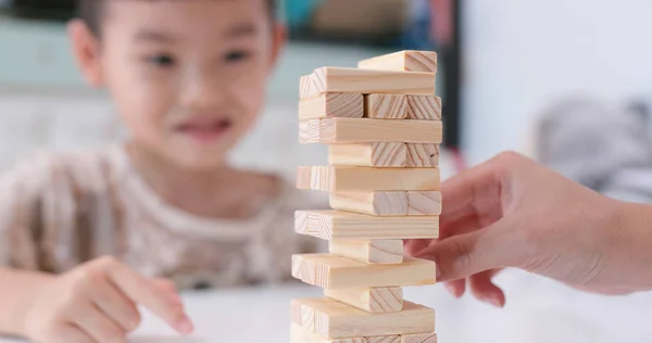 Asian kid play with wooden block tower