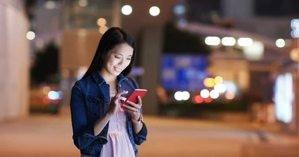 妇女站在路上 晚上用手机 — 图库照片