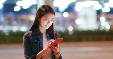 Kadın iş üstünde hareket eden telefon City geceleri