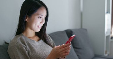 Evde cep telefonu kullanan bir kadın