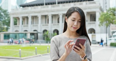 şehirde cep telefonu kullanan kadın